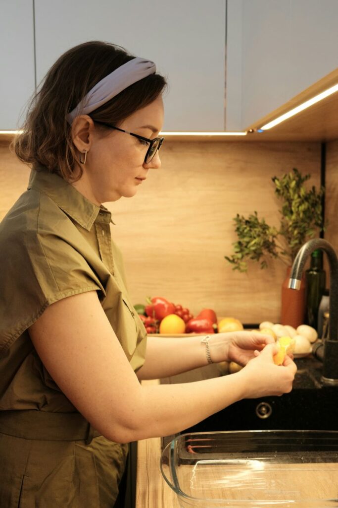 Woman in kitchen preparing different vegetables