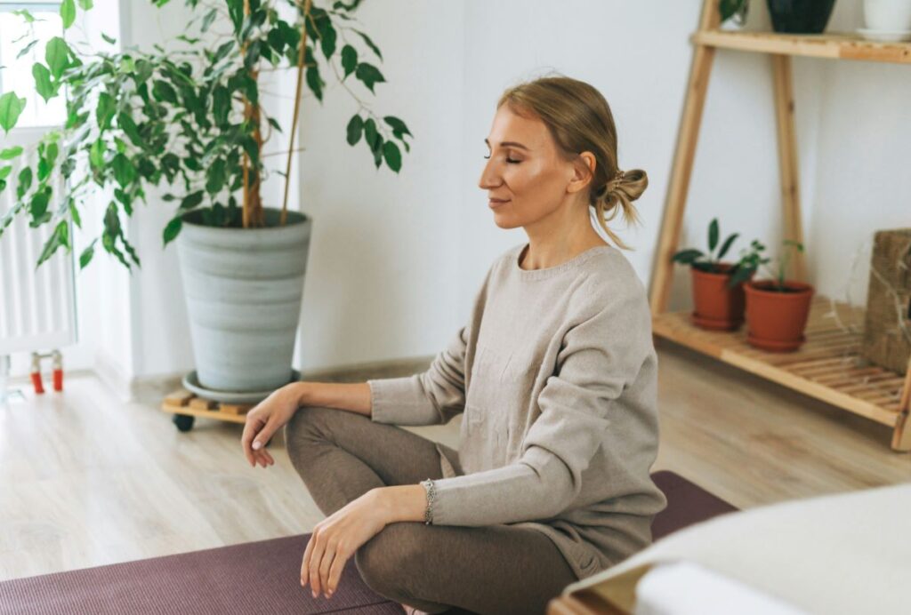 Woman practicing self-love by sitting quietly and meditating