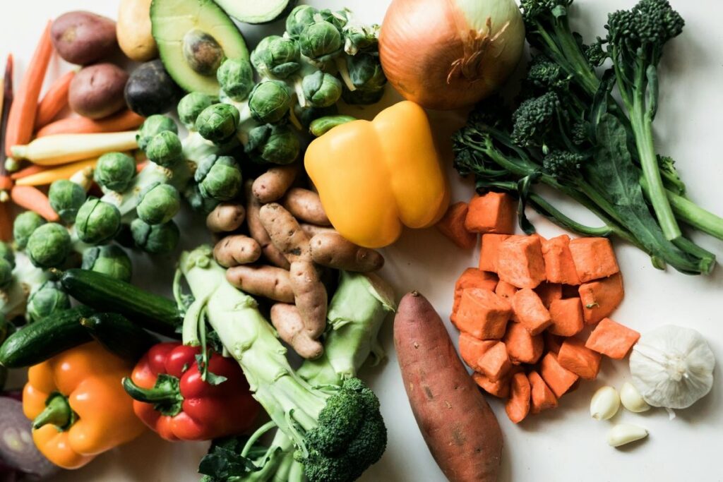 Variety of fresh vegetables including broccoli, peppers, sweet potatoes and brussels sprouts