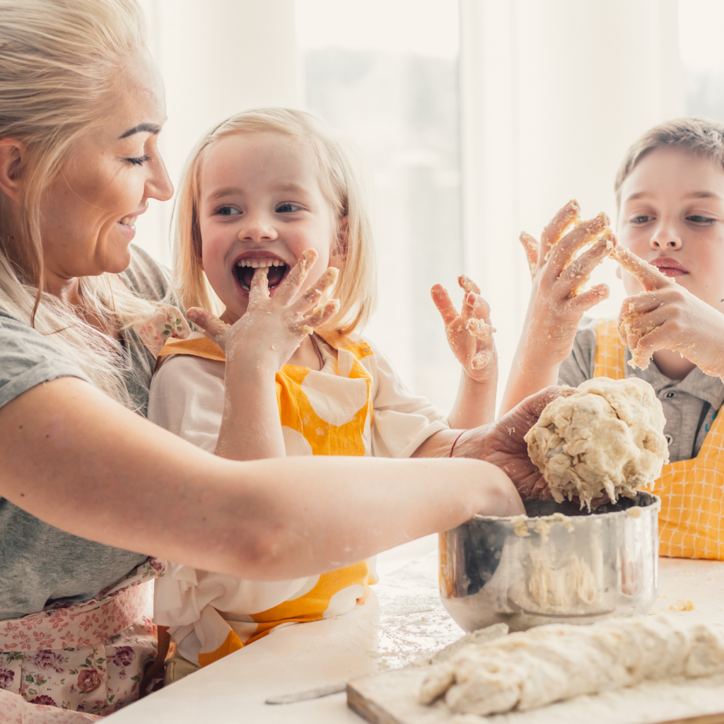 A mom having fun cooking with her kids, focusing on connection and holiday self-care for moms.