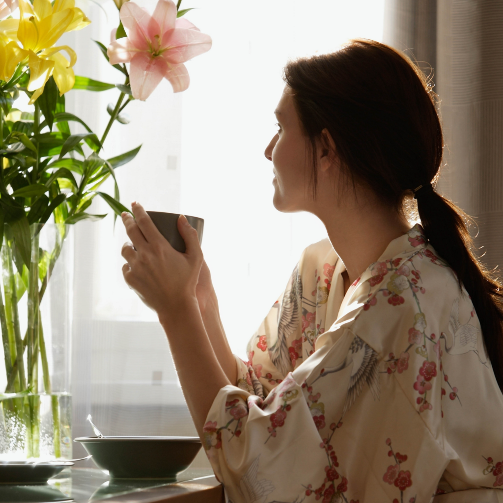 A steaming cup of tea and soft morning light streaming through a window for a calm start to the day.