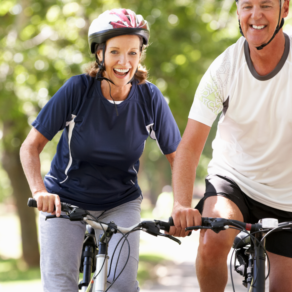 Middle-aged couple enjoying a bike ride together, promoting movement as a way to improve heart health during menopause.