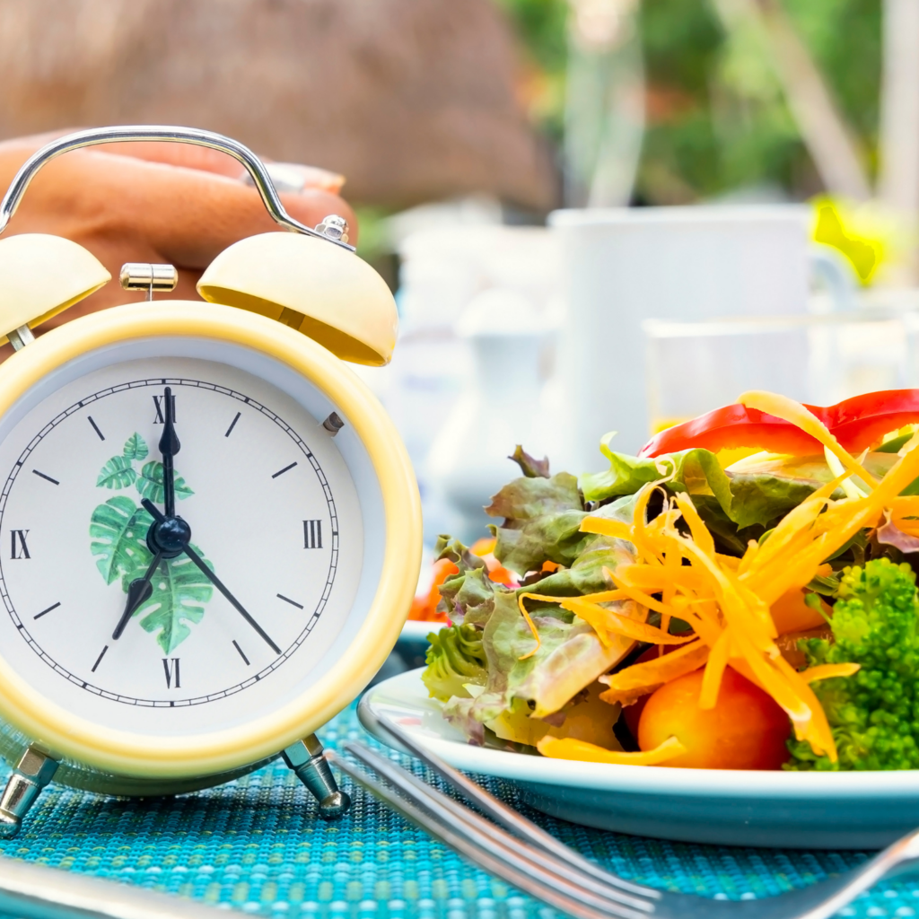 A clock and healthy meal illustrating how eating windows support hormone health and reduce midlife weight gain