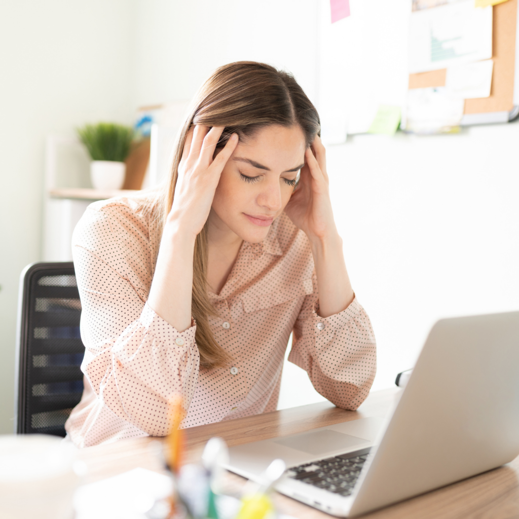 A stressed midlife woman at her computer, illustrating how stress contributes to midlife weight gain
