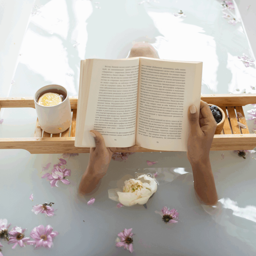Woman enjoying a bath, tea, and reading as part of a slow wellness routine
