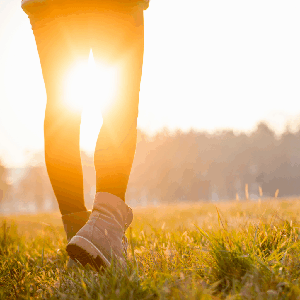 A woman walking in nature at golden hour.